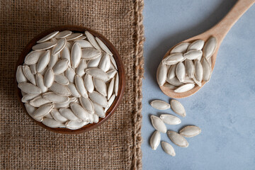 A bowl full of pumpkin seeds on bright background,closeup