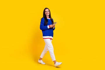 Fototapeta na wymiar Full body length photo of cheerful brunette smiling lady with smartphone seems not really busy person isolated on yellow color background