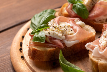 Deliziose bruschette condite con prosciutto crudo e mozzarella, antipasti italiani, cibo europeo 