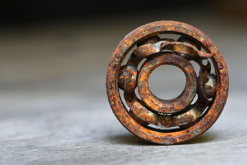 old rusty and damaged ball bearing on wood table . corrosion of steel 