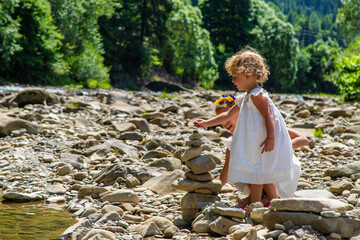 Children throw stones into the river. Selective focus.