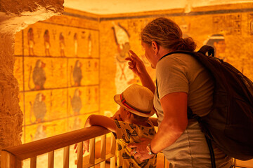 a tourist watching the  sculptural details on the wall of the temple of the Tutankhamun king,...
