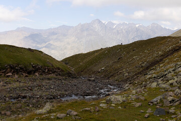 Group of tourists hiking in Caucasus mountains in Georgia on mount Kazbegi