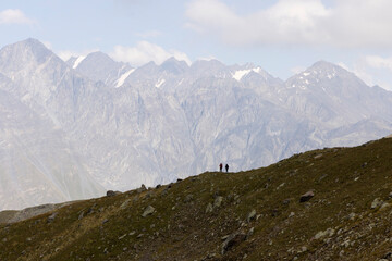 Group of tourists hiking in Caucasus mountains in Georgia on mount Kazbegi