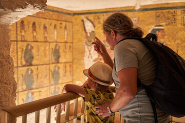 a tourist watching the  sculptural details on the wall of the temple of the Tutankhamun king, Luxor, Egypt.Tomb of pharaoh Tutankhamun in Valley of the Kings, Luxor, Egypt