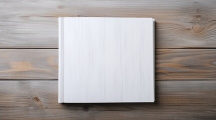 Naklejka na ściany i meble White book on wooden table. Mockup for design, education or branding to place your text.