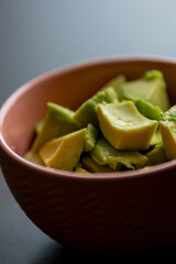 Cut Avocado Cubes Close Up in Pink Small Bowl - Fresh and Vibrant Guacamole Prep