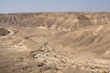 The dry riverbed in the desert landscape of the Negev in southern Israel during the summer. Desert nature.