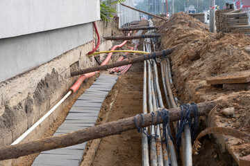 Construction work. Line of old and new cables buried underground on the street. underground electric cable infrastructure installation. Construction site with A lot of communication Cables