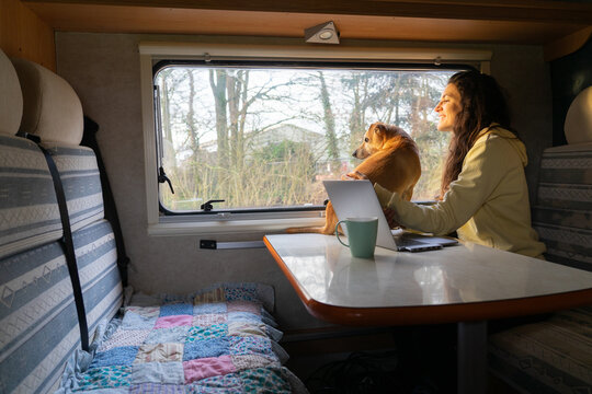Woman traveling in a motorhome and teleworking with her dog