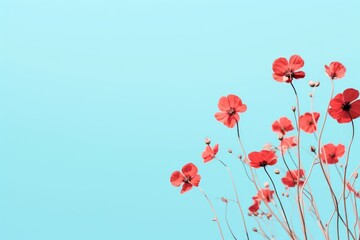  a bunch of red flowers sitting on top of a tree branch in front of a blue sky with only one plant in the foreground of the picture and a few red flowers in the foreground.