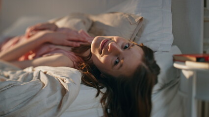 Closeup charming woman lying comfortable bed. Smiling girl dreaming look camera