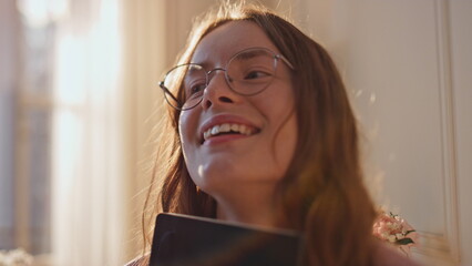 Smiling girl hug book diary in golden sunlight closeup. Dreamy teenager enjoy