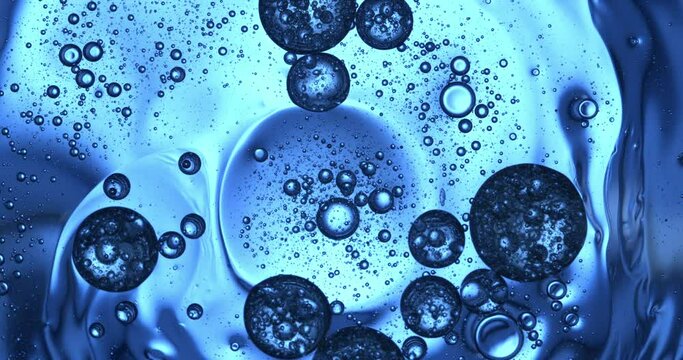Slow motion macro of floating micro particles molecules in liquid are analyzed with microscope by chemist during innovative new medical research and analysis in scientific pharmaceutical laboratory.