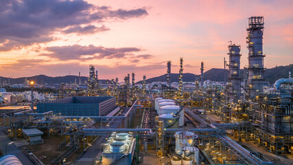 Oil and gas industrial refinery at twilight, Oil refinery and Petrochemical plant pipeline steel, Refinery factory oil storage tank and pipeline steel at night. - Powered by Adobe