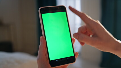 Hand swiping chromakey smartphone screen closeup. Unknown user browsing internet