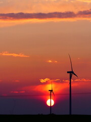 Obraz premium Coucher de soleil avec les éoliennes dans la Beauce
