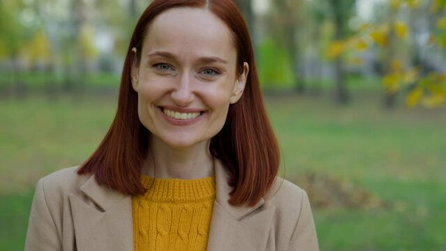 Portrait happy smiling laughing positive carefree cheerful glad woman Caucasian girl lady female in autumn park laugh smile looking at camera fun good mood satisfied toothy healthcare health dental