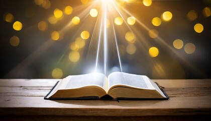 open bible with a light coming from above on a wooden desk