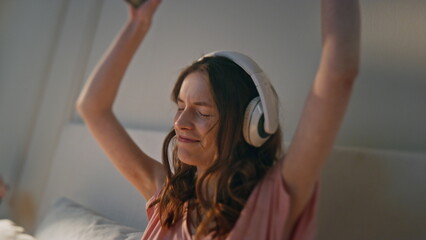 Happy girl dancing headphones at home closeup. Young woman listening music hold