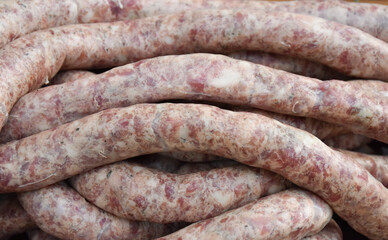 Raw long sausages texture background, close up. Fresh traditional homemade sausages texture