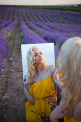 beautiful blonde in a yellow dress walks in a lavender field