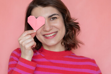 Happy woman holding heart shaped paper origami. Valentine's day concept card