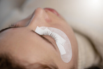 Woman making eylash extensions for a girl.