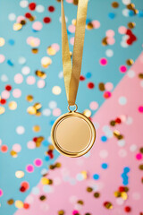 gold winner medal hanging on a pastel background with confetti and copy space	