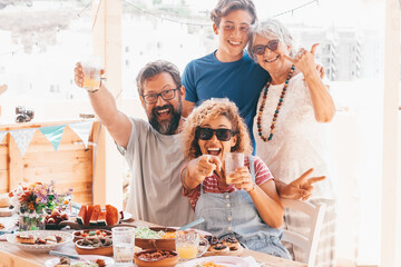 Beautiful happy multigenerational family having lunch together on the terrace at home. Parents, son...