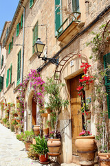 View of idyllic Valldemosa village old houses decorated with seasonal plants and flowers, Mallorca, Balearic Islands, Spain (no property release added as shop names and property have been deleted)
