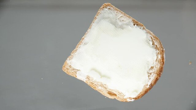 The sandwich always falls butter side down. Slow motion, close-up. Low angle view focus on window. sandwich law.