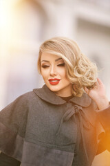 stylish girl in pin-up style with a fashionable hairstyle in an autumn coat against the backdrop of...