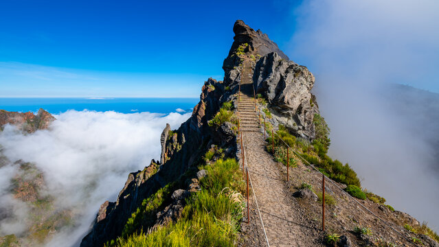 &ldquo;Ninho da Manta&ldquo; a panoramic walk  near &ldquo;Pico do Arieiro&ldquo; peak, Madeira island Portugal. Iconic mountain trail with steep precipice both sides the path. Scenic panorama with mist and blue sky.