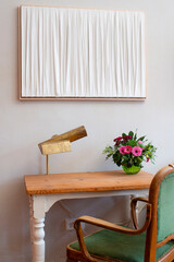 Simple wooden writing desk and green velvet chair.