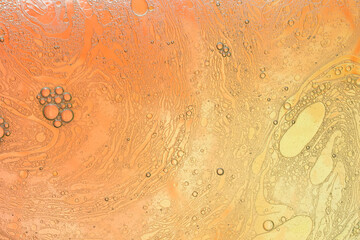 Macro shot of water-oil emulsion over colored background