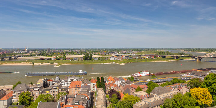 View at the Waal river with cargo riverboats passing the Dutch city of Nijmegen