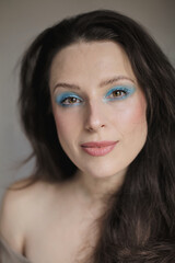 Obraz premium Portrait of a woman wearing bright light blue eyeshadow shade