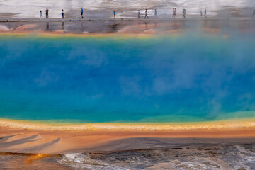 A line of visitors walking along the elevated path watching the colorful Grand Prismatic Spring, Yellowstone National Park, Wyoming