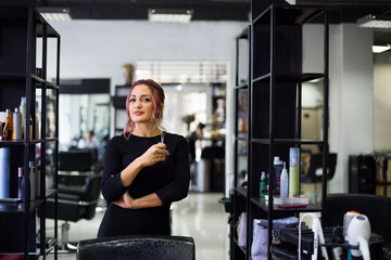 Fototapeta na wymiar Beautiful young hairdresser in beauty salon