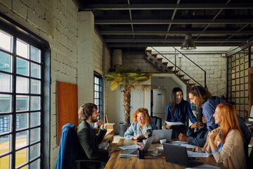 Team meeting of young diverse professionals in office