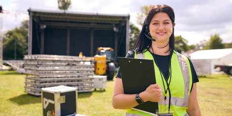 Portrait Of Female Production Worker Setting Up Outdoor Stage For Music Festival Or Concert