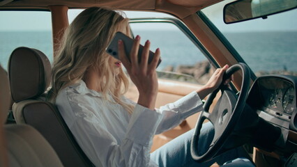 Annoyed woman calling phone sitting car close up. Girl hitting steering wheel