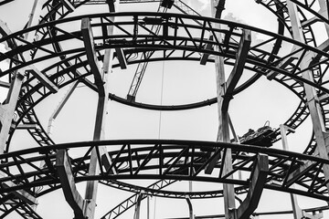 Black and white silhouette of a roller coaster ride design in an amusement park.