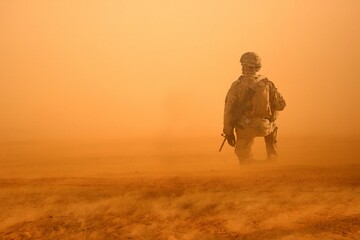 Military soldier between storm and dust at desert