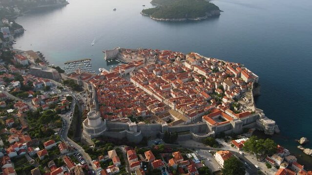 Aerial establishing view of old town of Dubrovnik with island on Adriatic sea, Dalmatia, Croatia. Medieval city fortress with harbor and yachts. Drone view. Travel destination