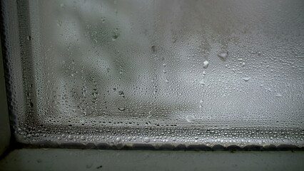 Condensation on glass during cold weather, winter season manifestation of droplets in macro closeup...