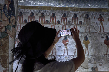 a tourist take a picture of King Seti tomb at the Valley of Kings .Luxor . Egypt. Hieroglyphics in...