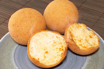 Delicious hot Colombian fritters on a plate on a wooden background. A steamy bread. Colombian Christmas food concept.