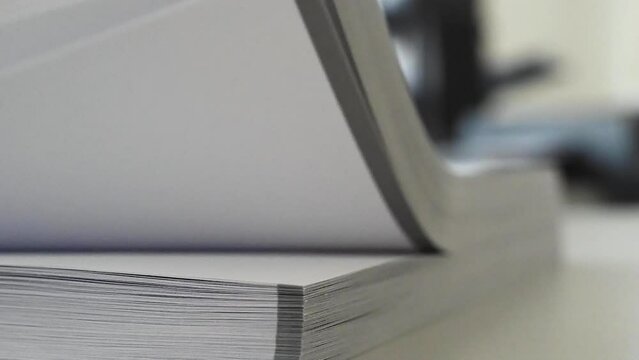 Turning, scrolling or flip paper in the print shop druckery during bookbindery book binding and cutting, collating stack paper.